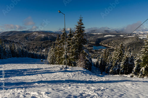 Beautiful panoramic view over the "Marisel" ski slope in winter season and Belis lake in the valley, Cluj county Romania. © rob3rt82