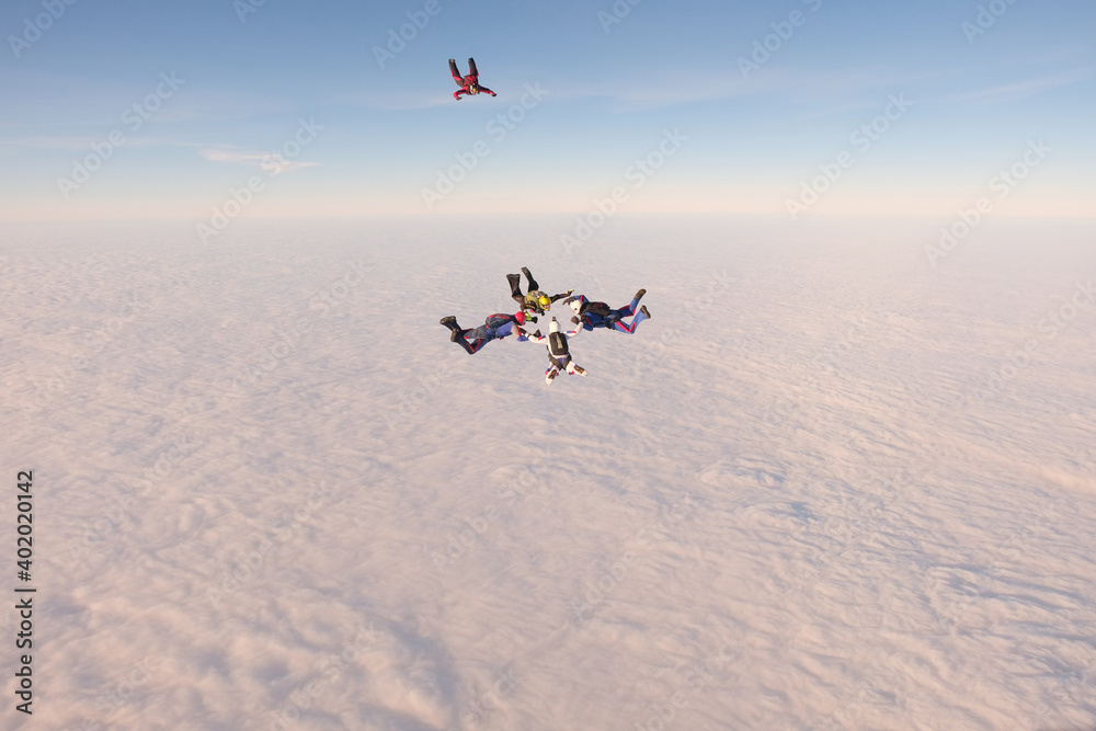 Skydiving. A team of skydivers is doing a figure in the sky. Group jump.