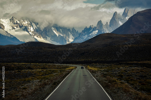 Asphalted road with the peaks of a rocky and snowy mountain on the horizon. Fitz Roy mountain in Argentina Horizontal Photograph
