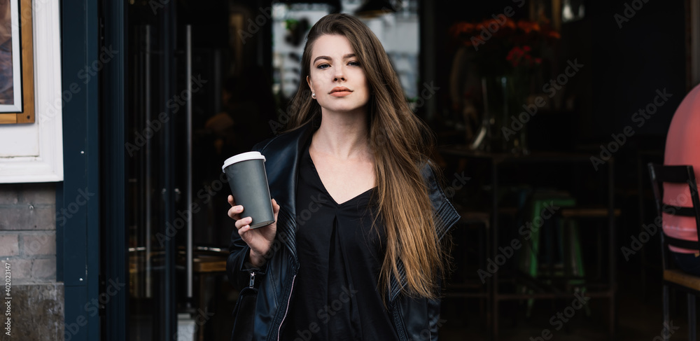 Young woman with coffee on city street