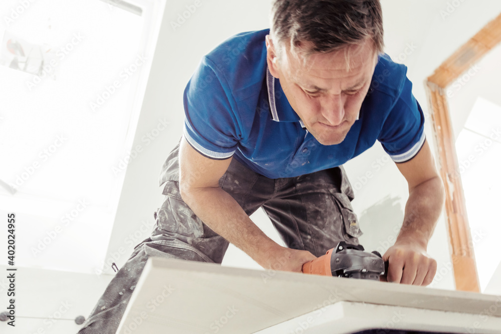Industrial tiler builder worker working with floor tile cutting equipmen Industrial tiler builder worker working with floor tile cutting equipmen
