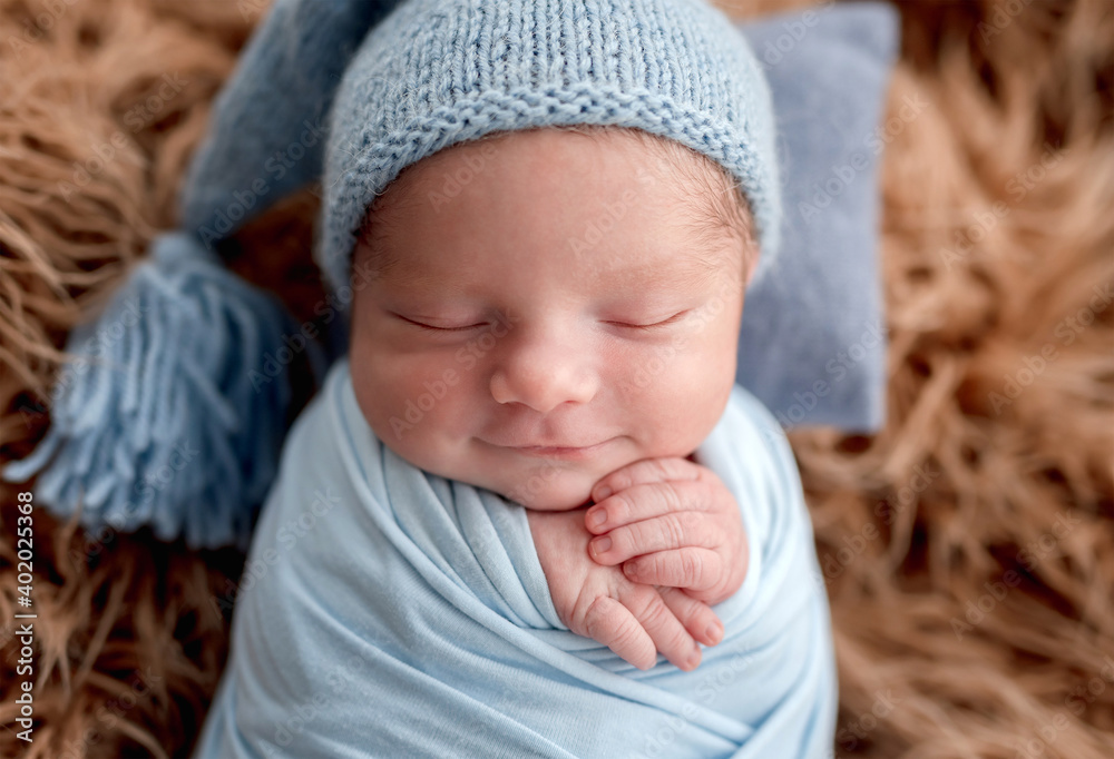 Smiling newborn holding toy while sleeping Smiling newborn holding toy while sleeping