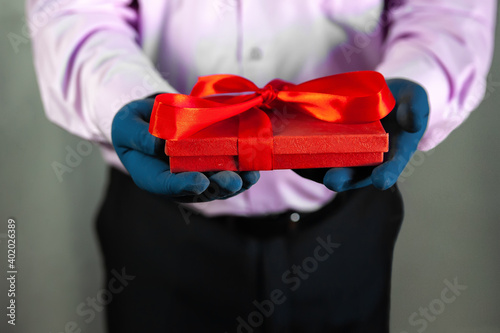Valentine's day gift. A man in rubber gloves holds a gift.