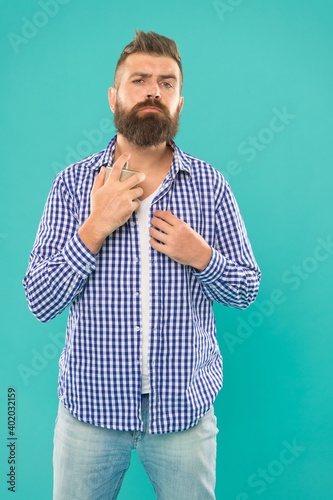 charismatic bearded man in casual checkered shirt hold male perfume bottle, fragrance.