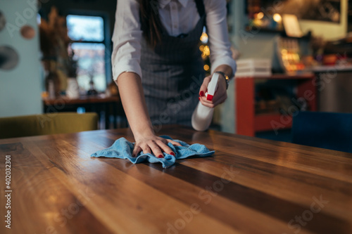 waitress cleaning tables in restaurant. corona virus concept