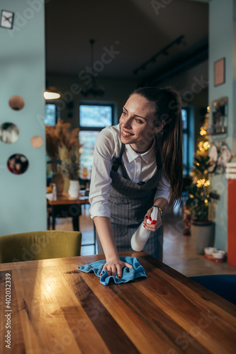 waitress cleaning tables in restaurant.