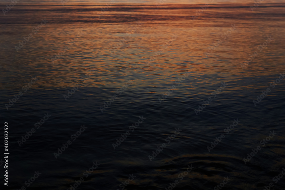 dark water with a reflection of a distant dawn