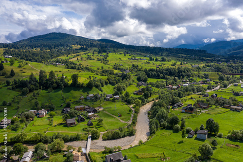 Mountains village landscape with River and Beautiful vintage wooden houses aerial view. © ronedya