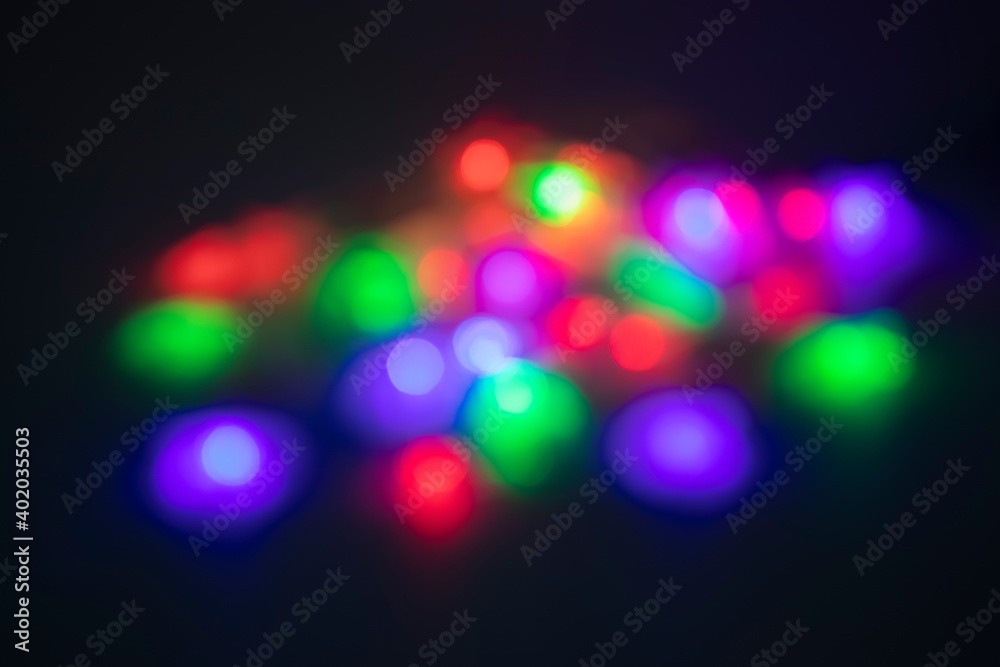 Christmas garland of colorful stars on black background. Christmas and New Year concept. Defocus.