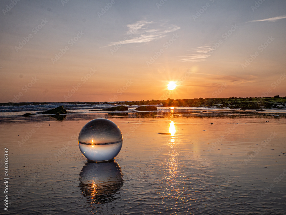 Glaskugel am Strand bei Sonnenuntergang Glaskugel am Strand bei Sonnenuntergang