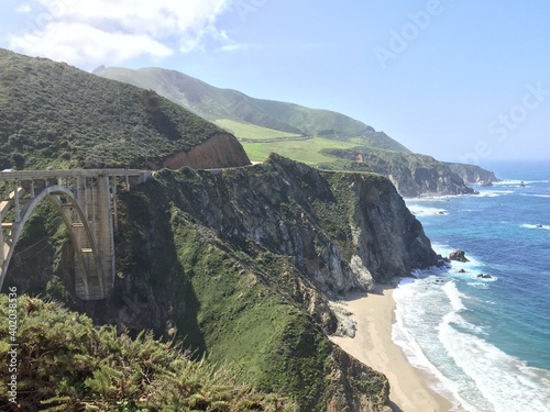 Beautiful landscape view of the Bixby Creek Bridge in Big Sur, California, USA, with the view of the Pacific Ocean coastline, beach and mountains on a sunny day.