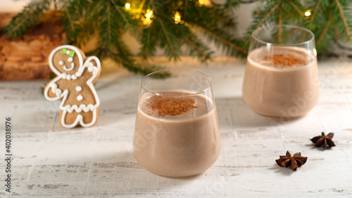 A glass of eggnog traditional winter drink with Ground cinnamon. Gingerbread man