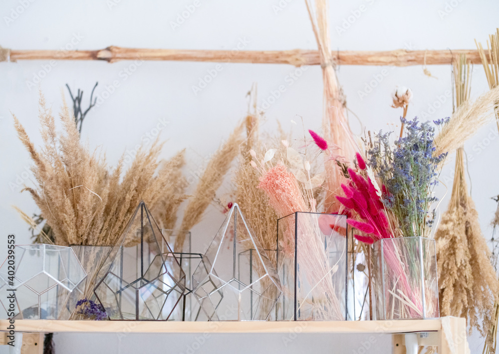 Bouquets of natural dried plants of dried flowers that retain their shape  and bright colors in glass vases for the art of making flower compositions.  Stock Photo