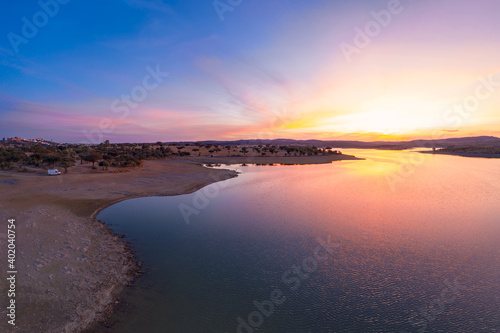 Drone aerial panorama of a dam lake reservoir with a camper van at sunset in Terena, Portugal