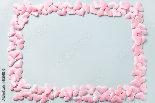 Frame of romantic pink hearts on blue background. Valentine's day greeting card with copy space. Love concept. © svetlana_cherruty