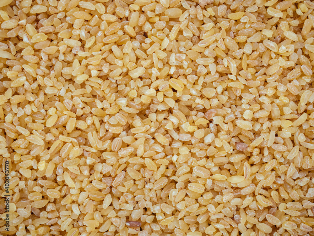 Raw bulgur wheat grain texture as background. Healthy, dietary, vegan, gluten free product. Healthy eating concept. Organic product made from wheat grains. Natural protein, fiber and fat. Top view. Raw bulgur wheat grain texture as background. Healthy, dietary, vegan, gluten free product. Healthy eating concept. Organic product made from wheat grains. Natural protein, fiber and fat. Top view.