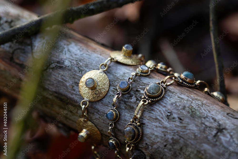 Fototapeta premium Three brass bracelets with labradorite stone on wooden background