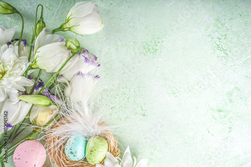Happy Easter concept. Spring Easter holiday top view  flat lay background with easter eggs in nests and spring flowers. Easter greeting card background with copy space.