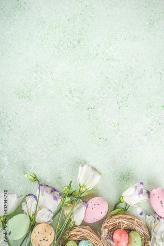 Happy Easter concept. Spring Easter holiday top view  flat lay background with easter eggs in nests and spring flowers. Easter greeting card background with copy space.