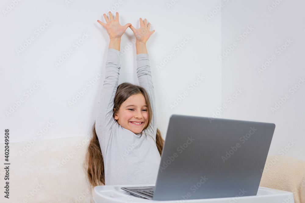 Portrait of attractive cute happy smiling girl 6-7 old sitting using laptop indoor white background distance learning Portrait of attractive cute happy smiling girl 6-7 old sitting using laptop indoor white background distance learning