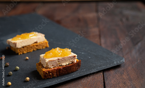 Foie gras toasts with candied onion and gingerbread on a slate