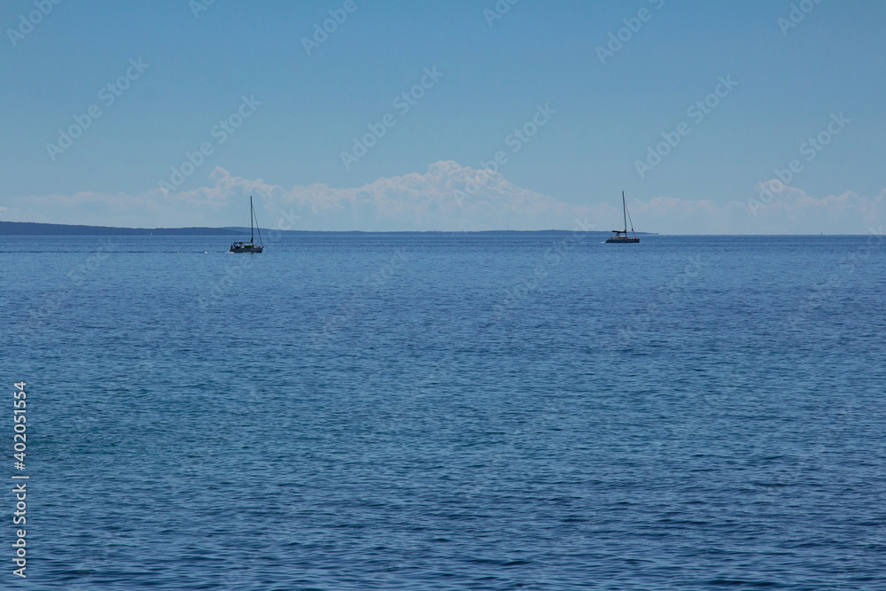 Two yachts sailing in the distance in Adriatic sea.