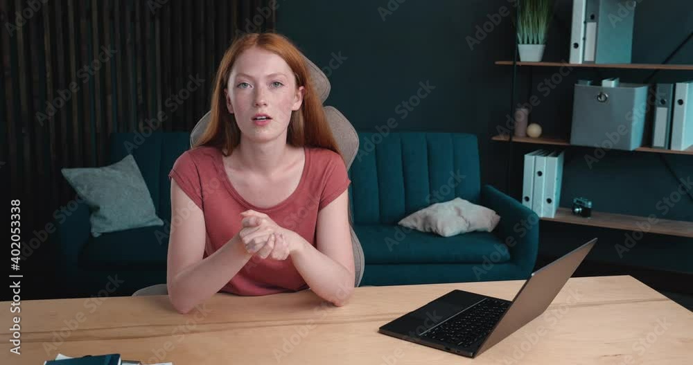 Young red-Haired Vlogger with Freckles recording new Vlog, talking to the Camera. Cute Ginger is holding Video Conference, Distance Studying. Online Job, Working Indoor. Cozy Home-Office. Young red-Haired Vlogger with Freckles recording new Vlog, talking to the Camera. Cute Ginger is holding Video Conference, Distance Studying. Online Job, Working Indoor. Cozy Home-Office.