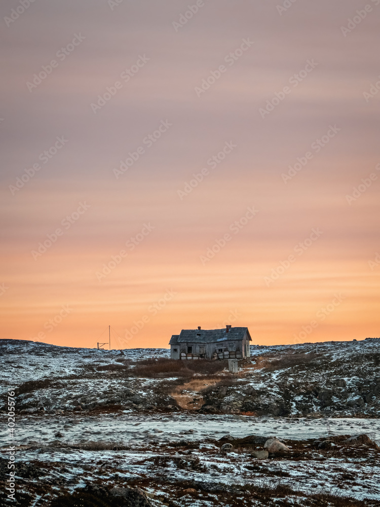 Abandoned house against the evening Arctic sky. Old authentic village of Teriberka.