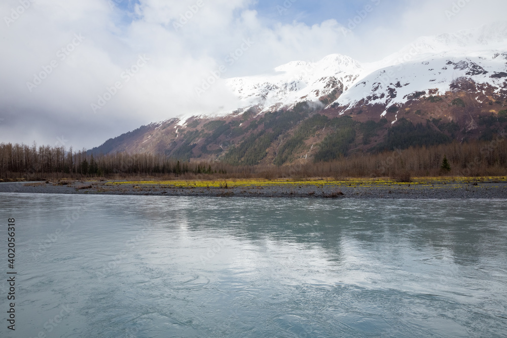 Snow capped mountains in clouds and blue waters of Portage Creek, Alaska Snow capped mountains in clouds and blue waters of Portage Creek, Alaska