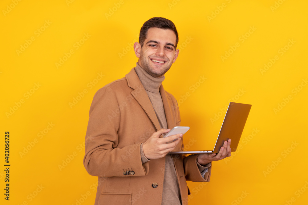 young man with smartphone and laptop isolated on background young man with smartphone and laptop isolated on background