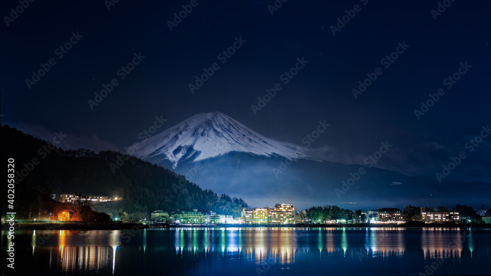Superbe panorama sur le Mont Fuji vue de nuit depuis le lac de Kawagushiko avec la ville d'Oishi éclairée, Japon