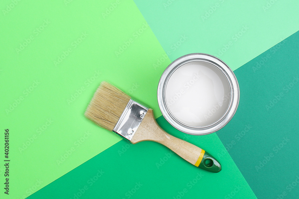 Open paint enamel cans on color palette samples. The concept of repair, construction. Shades of green. Open paint enamel cans on color palette samples. The concept of repair, construction. Shades of green.