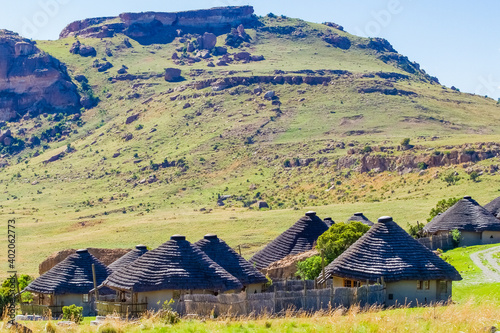 A small village of African rondavels on background of a rocky hill photo