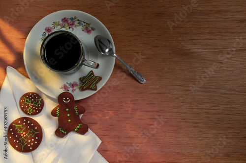 Taza de café con galletas de jengibre sobre una mesa de madera.