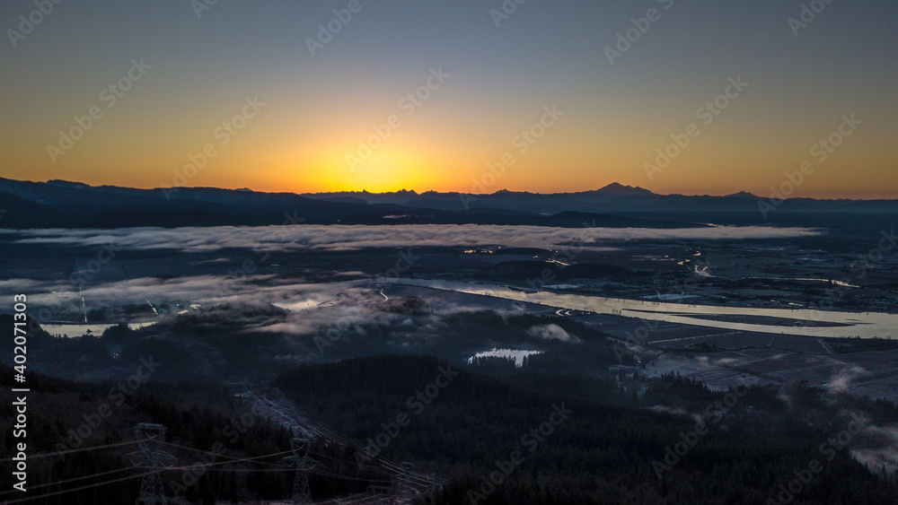 Seconds before sunrise over mountain ranges with river and mist foggy clouds
