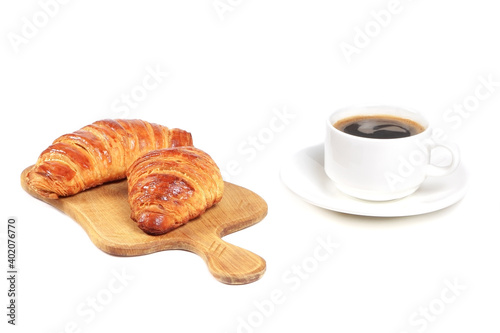 Croissants and cup of coffee isolated on a white background. Breakfast with Fresh pastry. Croissants on a cutting board.