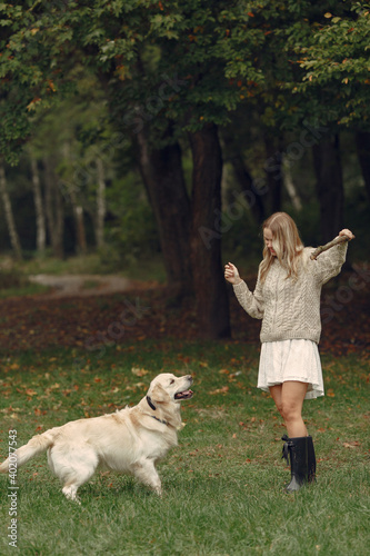 Woman in a brown sweater. Lady with a labrador. Friends are having fun outside.