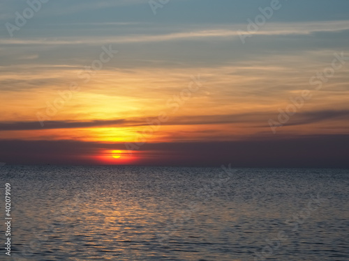Fototapeta Naklejka Na Ścianę i Meble -  The sun is setting on the beach and the calm waters are beautiful.