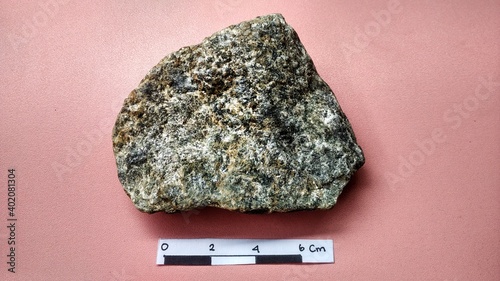 Schistmica metamorphic rock foliated structure on pink background. With quartz, muscovite, garnet, chlorite, calcite, apatite on Melange tectonic zone, Indonesia. Ophiolite area  photo