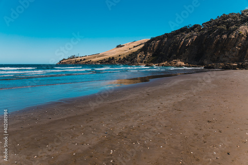 Fototapeta Naklejka Na Ścianę i Meble -  pristine wild landscape at Clifton Beach in Tasmania, Australia with wavy blue ocean and golden sand next to a rugged coastline