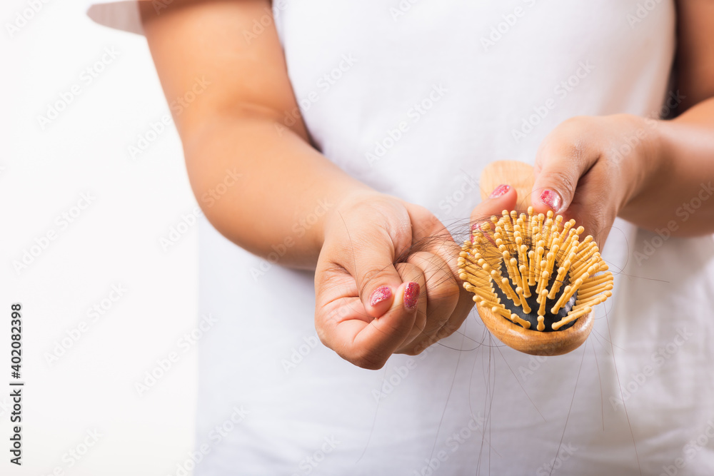 Obraz premium Asian woman unhappy weak hair problem her hold hairbrush with damaged long loss hair in the comb brush she pulls loss hair from the brush, isolated on white background, Medicine health care concept