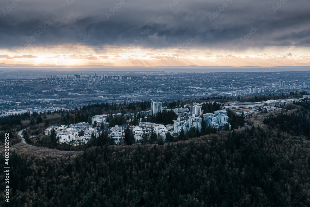 Obraz premium Striking Aerial view of Burnaby Mountain during a dramatic cloudy sunset. Taken in Vancouver, British Columbia, Canada.
