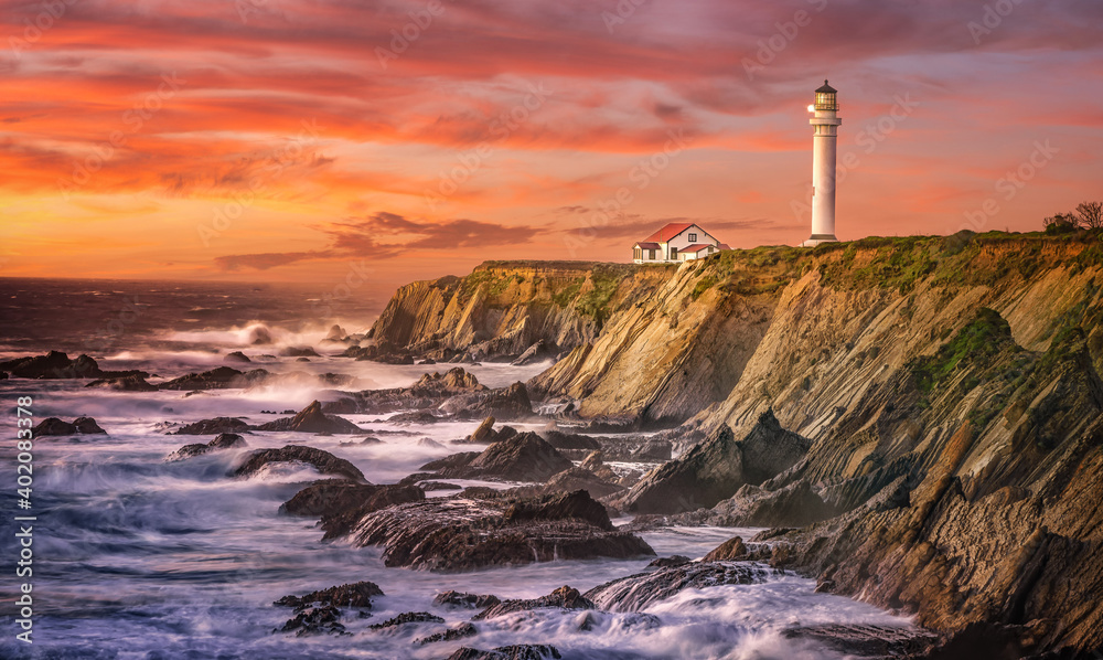 lighthouse near rocky beach with sunset