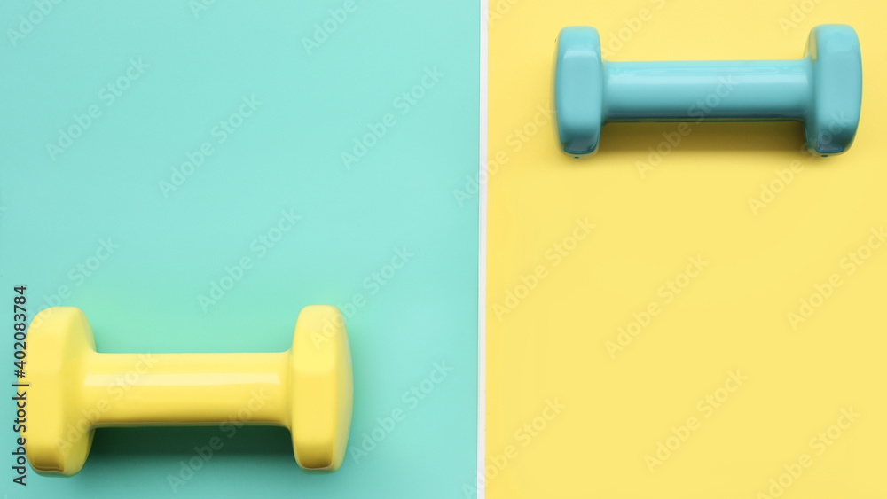 close up of dumbbell on green and yellow background close up of dumbbell on green and yellow background