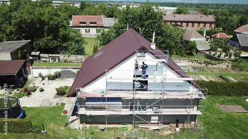 Workers to renovate a house. Aerial shot of thermal insulation of the facade of a family house.
