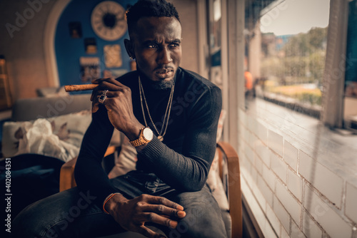 portrait of african american man holding cigar on hand in coffee shop