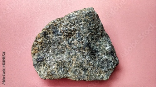 Schistmica metamorphic rock foliated structure on pink background. With quartz, muscovite, garnet, chlorite, calcite, apatite on Melange tectonic zone, Indonesia. Ophiolite area  photo