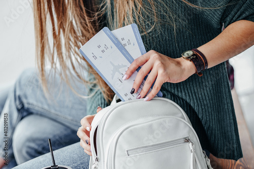 Woman hand put a boarding pass in bag. Hand holding tickets. Waiting for aircraft and travel