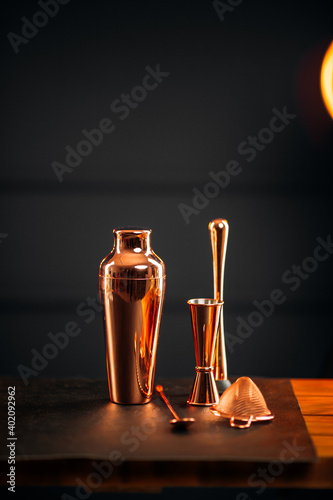 Side view on copper bar tools set with shaker on the wooden table photo