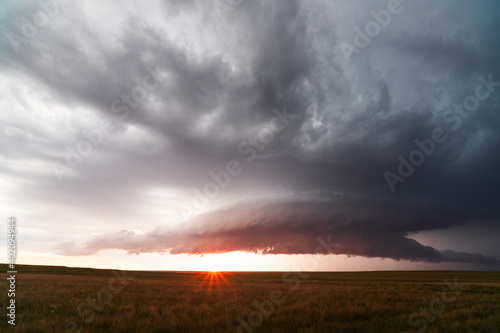 Supercell thunderstorm with dark storm clouds at sunset © JSirlin